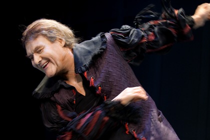 Johan Rabeus i rollen som Harpagon. Han är iklädd en lila åtsittande dräkt och ser ut att dansa.